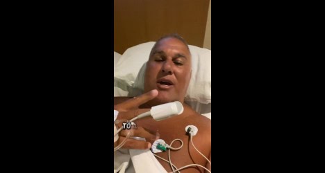 Homem deitado em hospital, com equipamento médico.