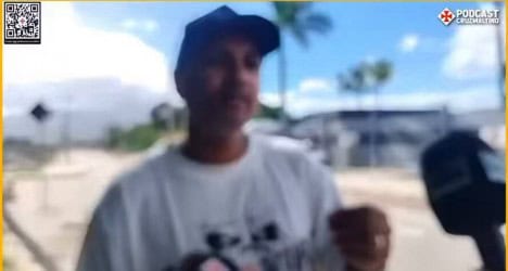 Homem sorridente usando boné cinza ao ar livre.