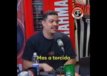 Homem falando em podcast com microfone.
