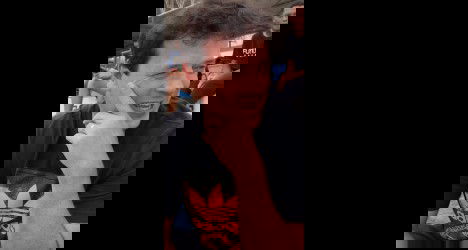 Homem sorridente com cabelo escuro.