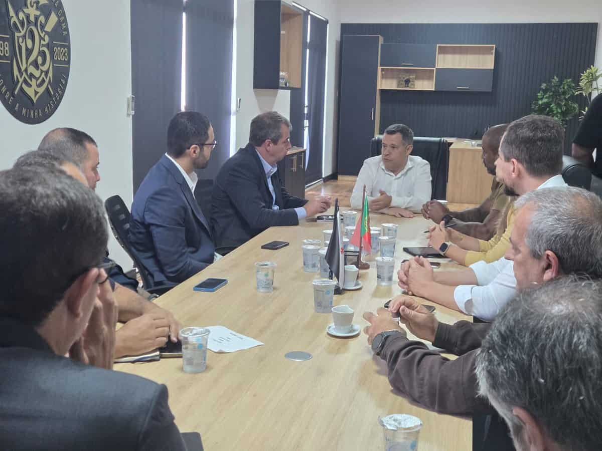 Reunião de negócios com pessoas em torno de mesa.