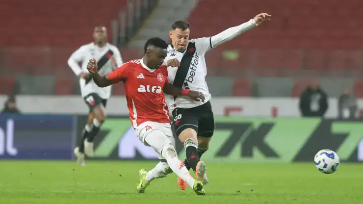 Jogadores de times diferentes disputam a bola.