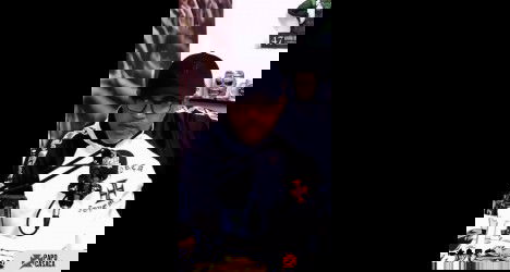 Homem com óculos e boné fala em microfone.