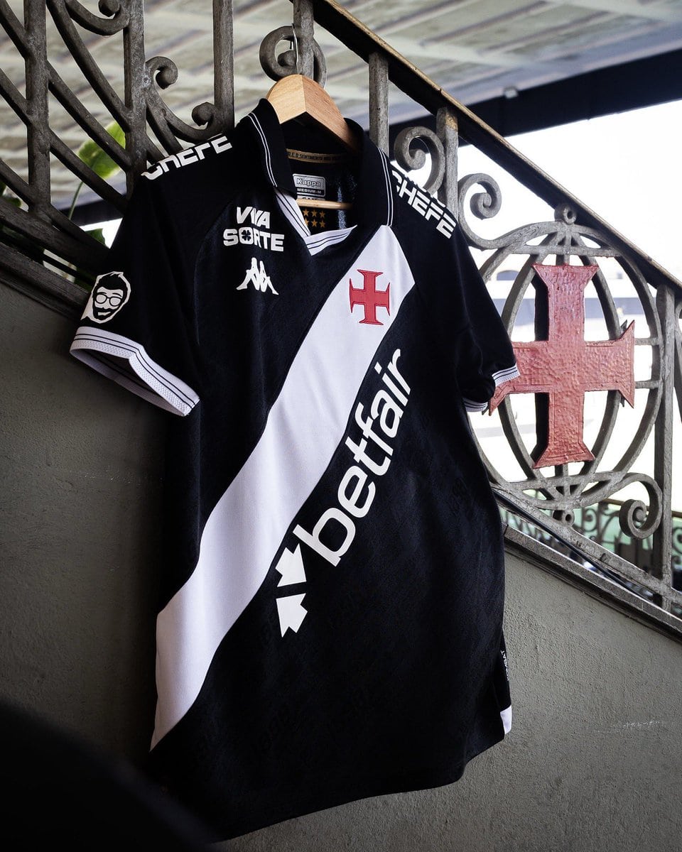 Camisa do Vasco da Gama, time de futebol, pendurada em um varal numa varanda, com detalhes de marcas e símbolo do clube.