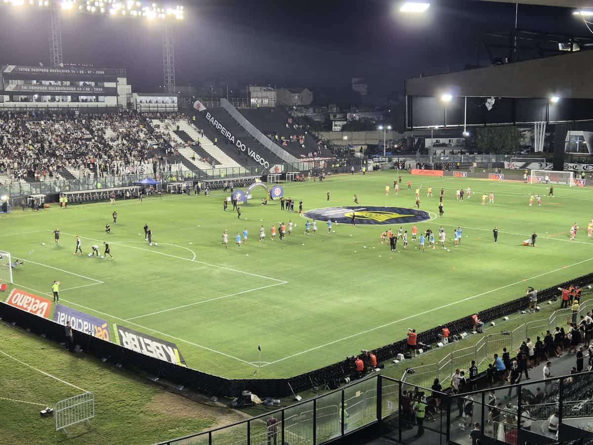 Jogadores e comissão técnica em atividade no campo de futebol.