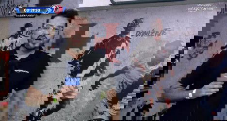 Reportagem do Vasco na transmissão ao vivo, com apresentador falando na câmera, fundo com símbolos do clube e jogadores em destaque.