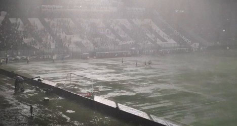 Chuva forte causa alagamento no campo de jogos do Vasco. Visibilidade reduzida e condições adversas durante o jogo.