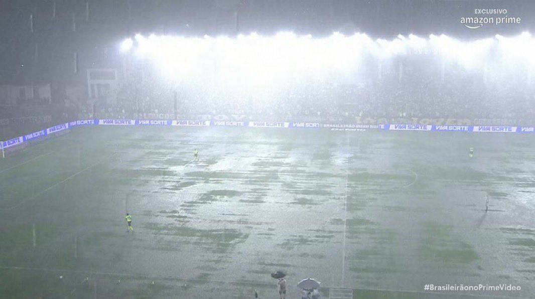 Campo de futebol alagado pela chuva forte.