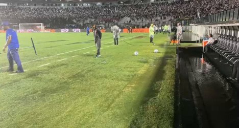 Atletas treinando no campo com bolas e treinadores.