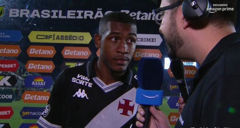 Jogador sendo entrevistado com microfone na mão.