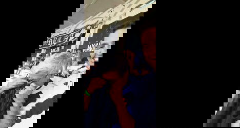 Homem sorrindo e segurando uma camiseta do Vasco, visivelmente emocionado, em um estádio lotado, celebrando um momento especial do clube.