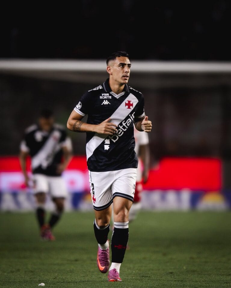 Jogador do Vasco correndo em campo com uniforme oficial.