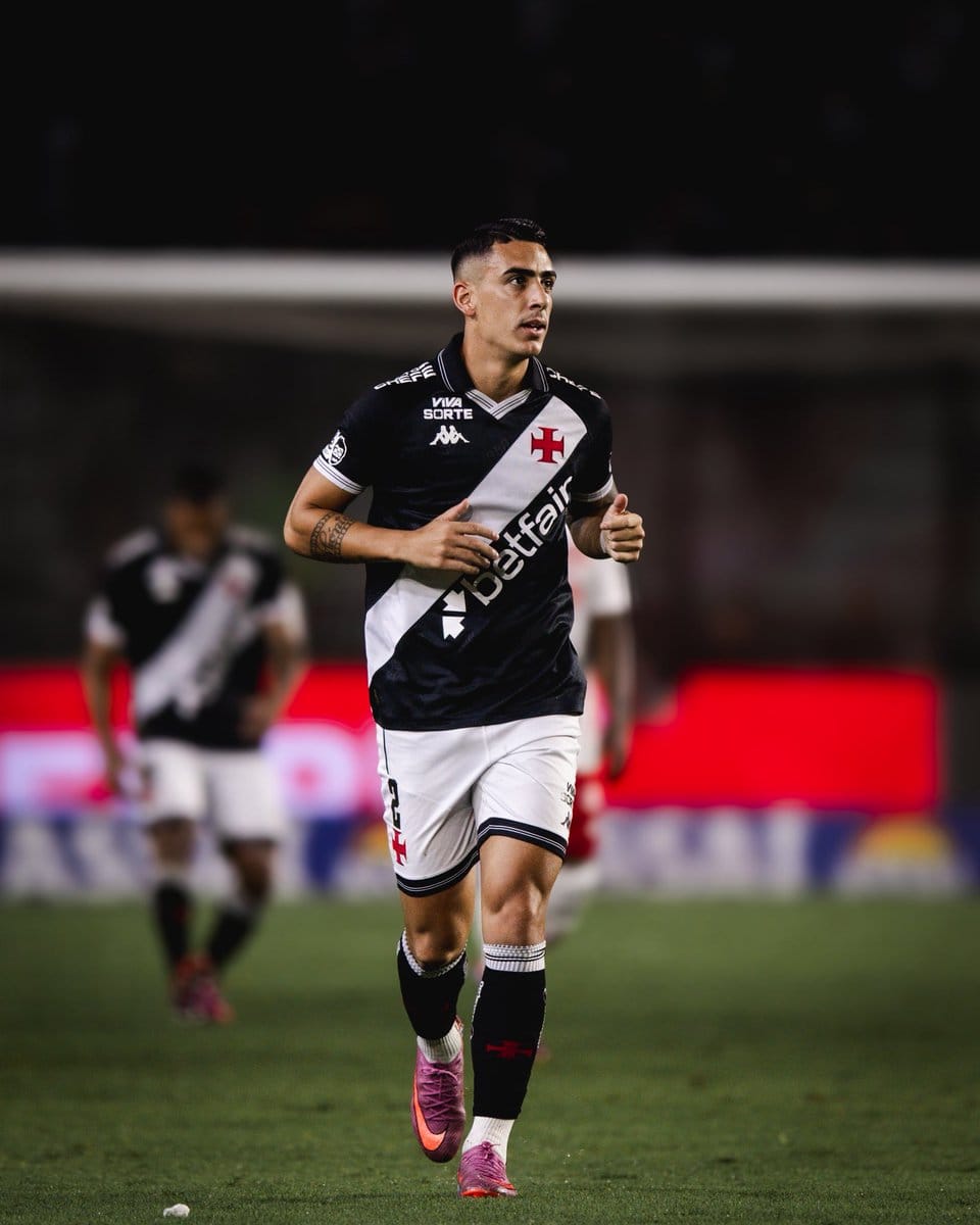 Jogador do Vasco correndo em campo com uniforme oficial.