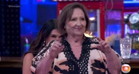 Vovó sorridente com roupas casuais em ambiente de festa.