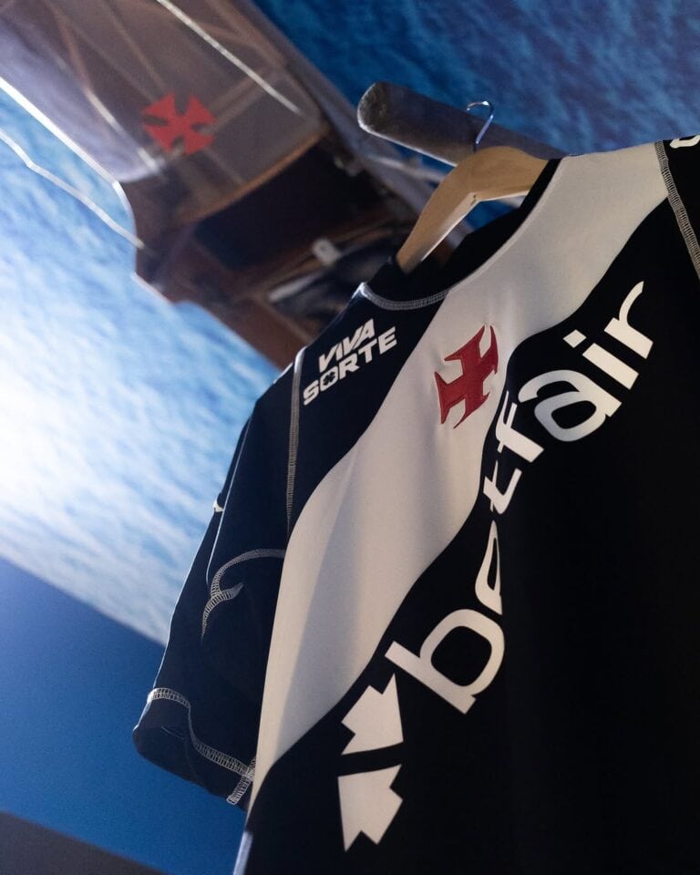 Camisa de time do Vasco da Gama, com cores preto e branco, logotipo e patrocinador visíveis.