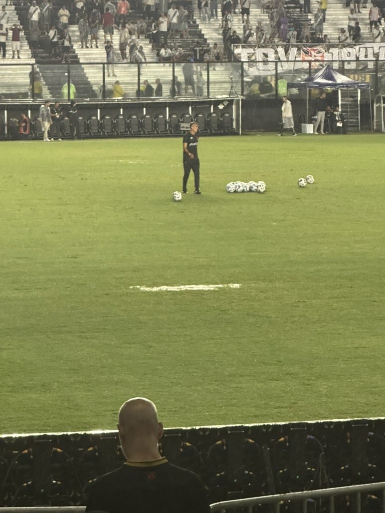 Jogador treinando com bolas no gramado.