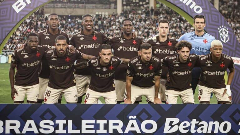 Imagem de jogadores do Vasco da Gama em uma partida, vestindo o uniforme do clube com o logo e patrocinadores visíveis durante jogo oficial.