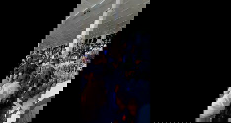 Torcedores do Vasco em partida no estádio, com torcida animada e assentos ao fundo, demonstrando entusiasmo eapreço pelo clube.