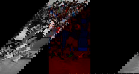 Jogadoras de vôlei do Vasco celebrando pontuação com torcida ao fundo.