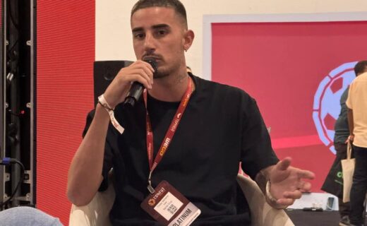 Homem falando ao microfone em evento.