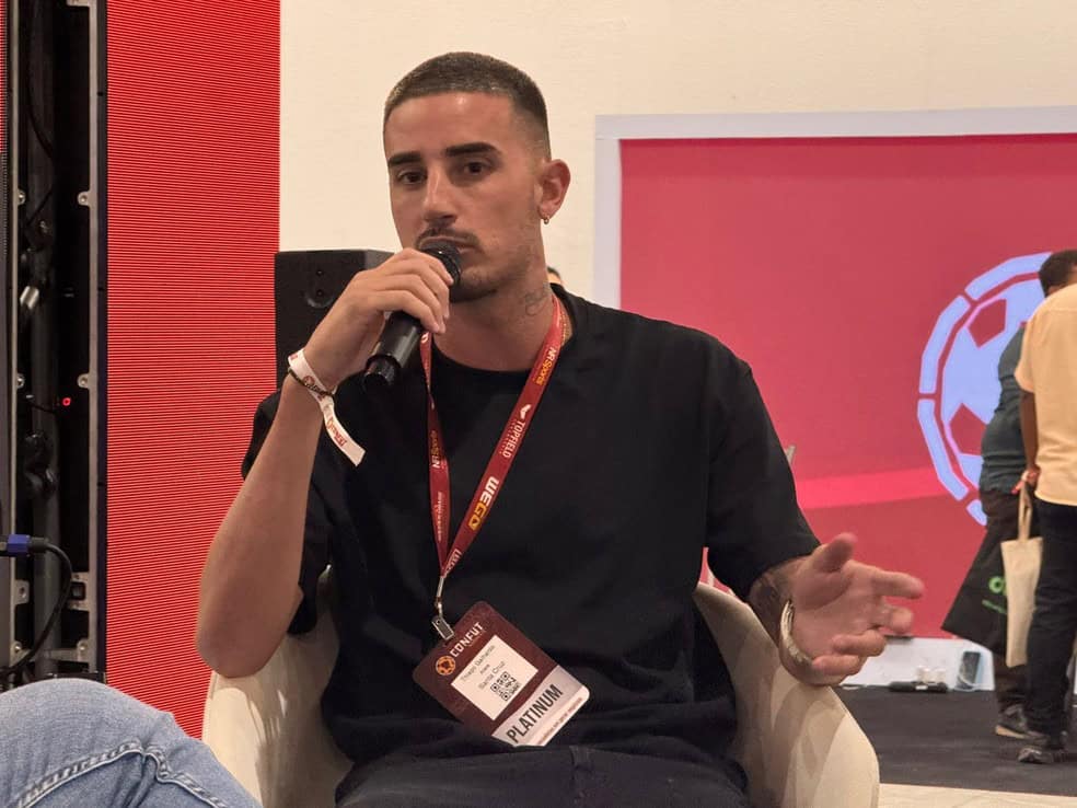 Homem falando ao microfone em evento.