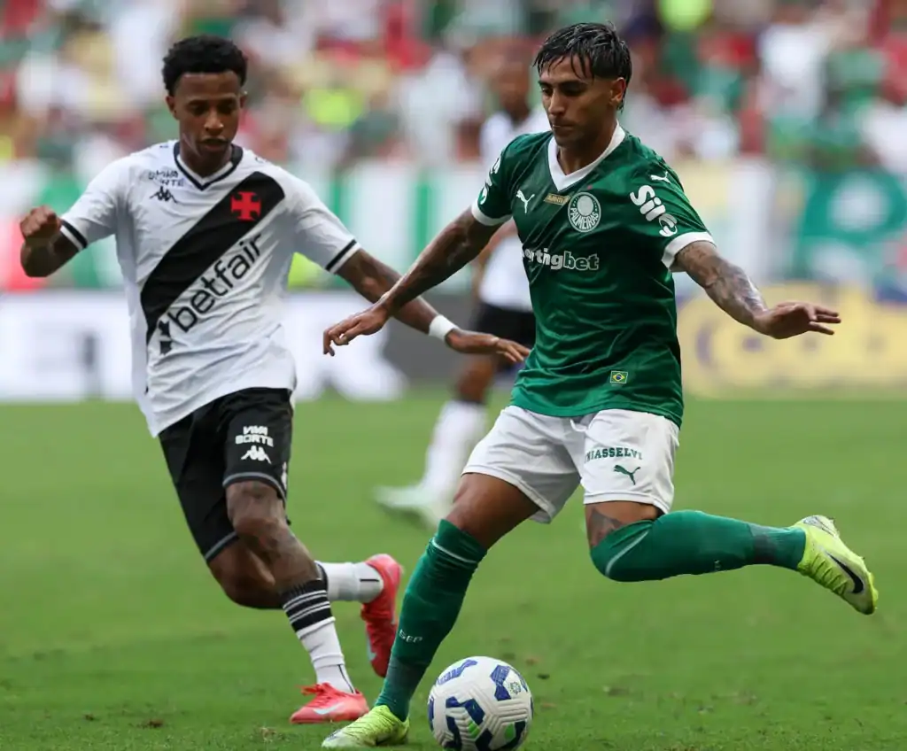 54497252340_9592507408_h-1024x848-1 Jogadores em ação durante partida de futebol.