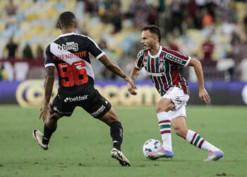 Jogo de futebol entre dois jogadores em campo aberto.
