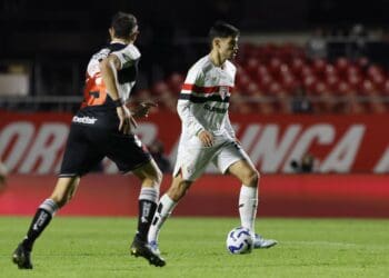 Jogador do São Paulo controlando a bola em jogo.