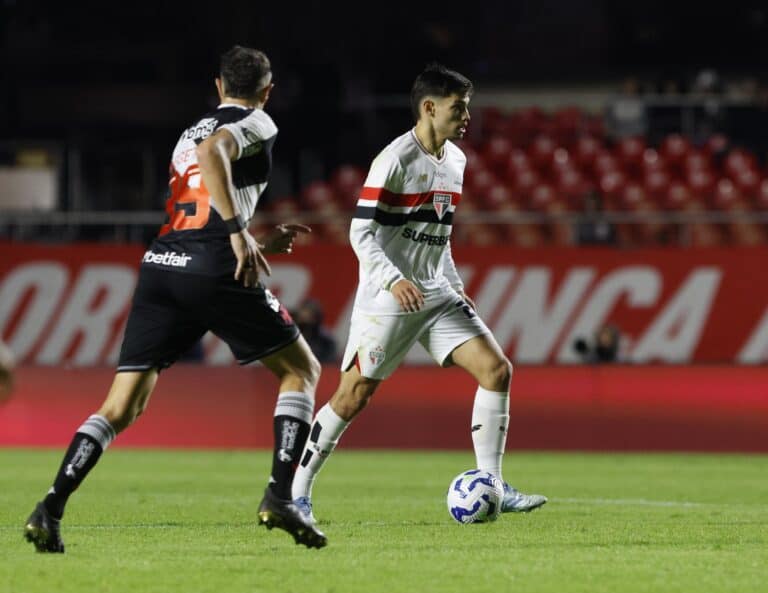 Jogador do São Paulo controlando a bola em jogo.