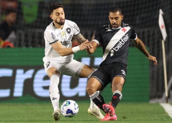 Jogadores de futebol disputando a bola em campo.