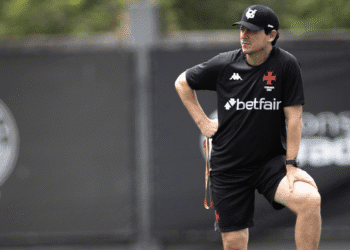 Treinador do Vasco observando treino em campo aberto.