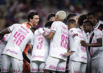 Vasco da Gama em momento de equipe no campo, jogadores de uniforme branco com detalhes em rosa.