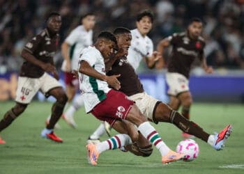 Salto de jogadores de futebol em campo.