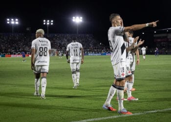 Jogadores do Vasco celebrando gol em campo durante noite de jogo.