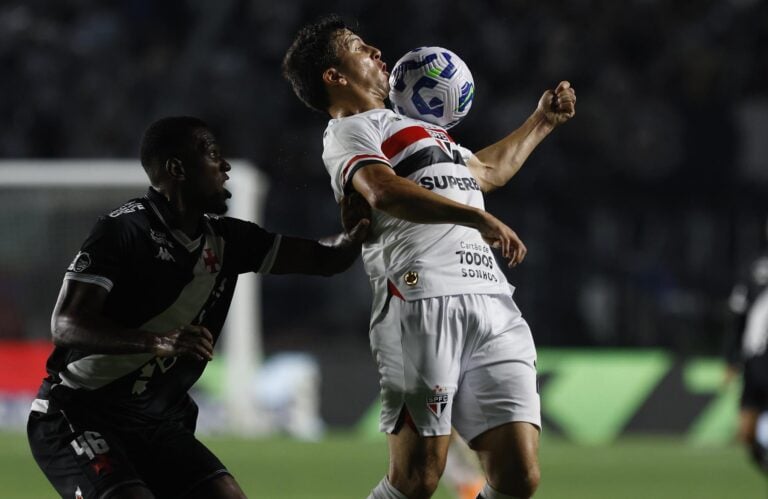 Jogo de futebol entre times do Vasco e rival, disputando a bola.