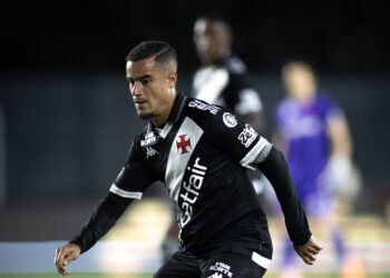 Jogador de futebol do Vasco em movimento.