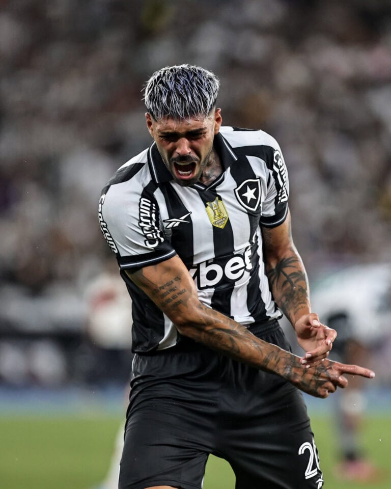 Bola de futebol com jogador do Vasco em ação.