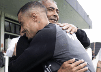 Abrace entre dois homens com camisetas do Vasco.