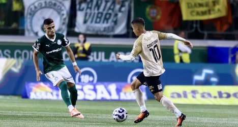 Jogador do Vasco dribla adversário em campo.