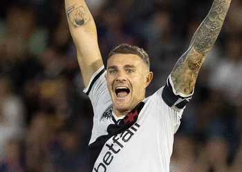 Jogador do Vasco comemorando gol com braços erguidos.