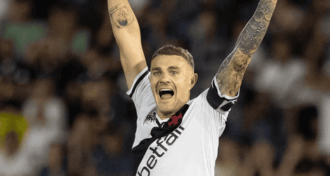 Jogador do Vasco comemorando gol com braços erguidos.