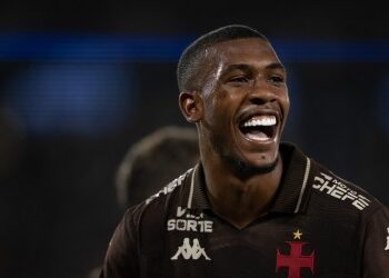 Jogador do Vasco sorrindo com uniforme preto.