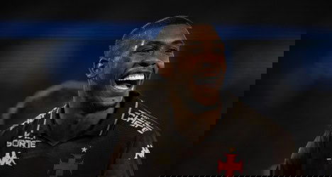 Jogador do Vasco sorrindo com uniforme preto.