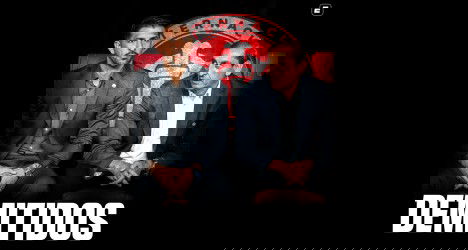 Homens sentados em reunião, atrás escudo do Vasco, com expressão séria.