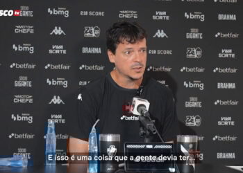 1. Homem falando em entrevista na sala de imprensa.