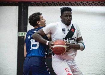 Atleta de basquete com bola em mãos, em disputa.