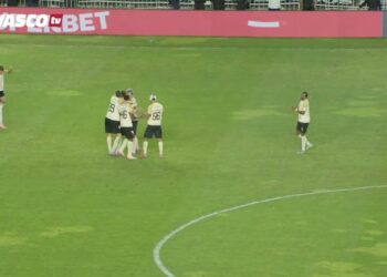 Jogadores do Vasco comemorando gol no campo de futebol.