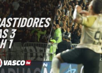 Goleiro comemorando torcida ao fundo.