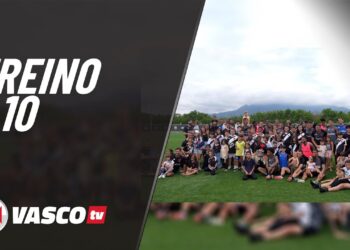 Grupo de pessoas em evento ao ar livre no campo de futebol.