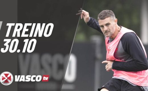 Futebolista treinando com colete rosa em campo.